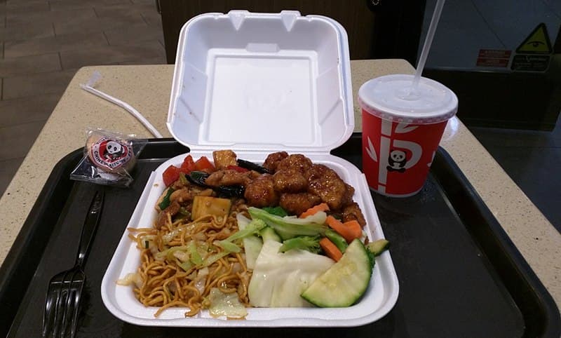 Panda Express-style plate with orange chicken, Kung Pao chicken, chow mein, and vegetables